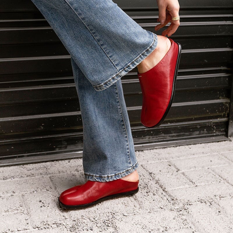 Pantuflas informales de piel con puntera dividida, planas y sin tal&oacute;n, en negro y rojo