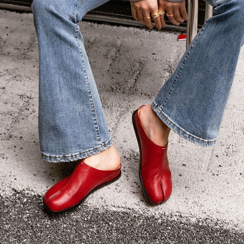 Pantuflas informales de piel con puntera dividida, planas y sin tal&oacute;n, en negro y rojo