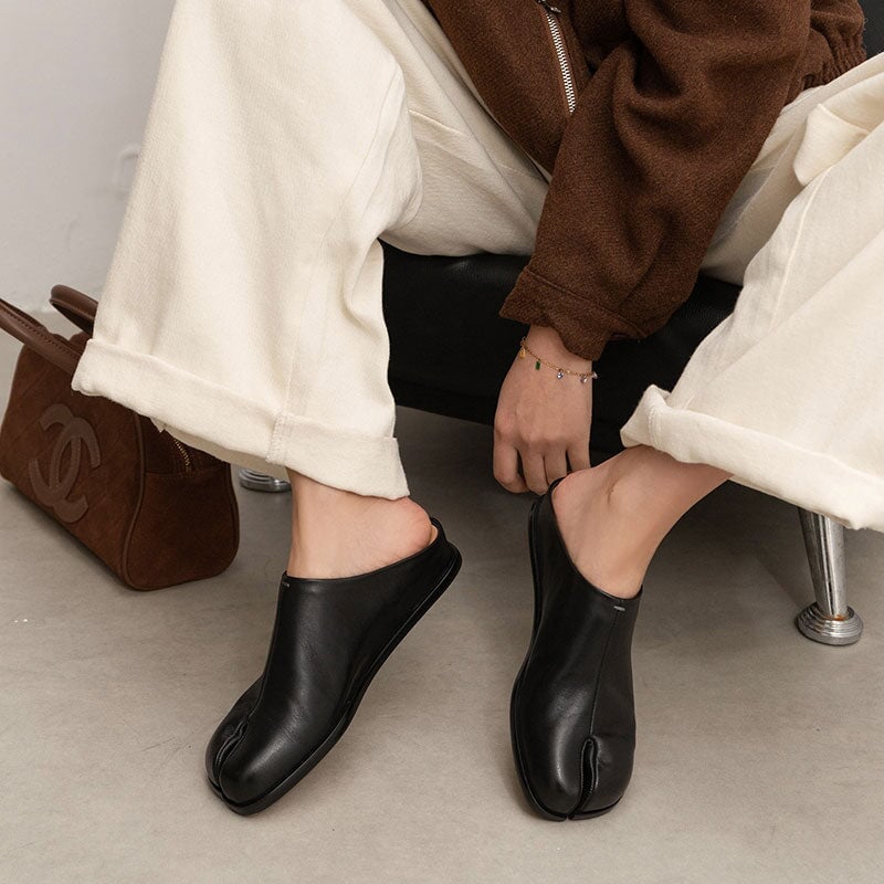 Pantuflas informales de piel con puntera dividida, planas y sin tal&oacute;n, en negro y rojo