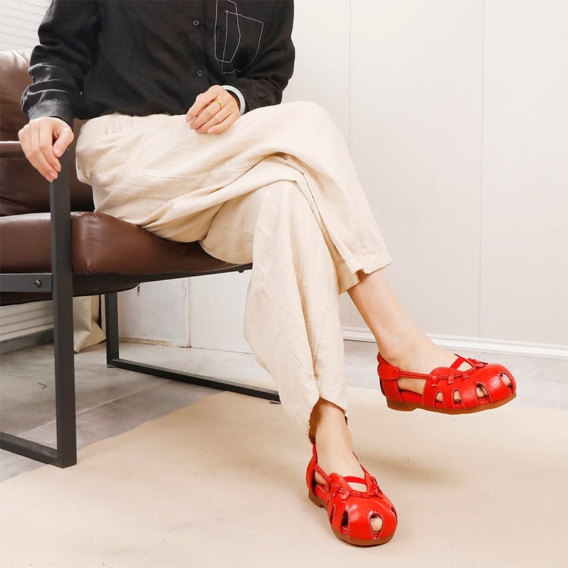Sandalias de cuero con dise&ntilde;o moderno y transpirable, con punta redonda y aberturas, con cierre de velcro en rojo y negro.