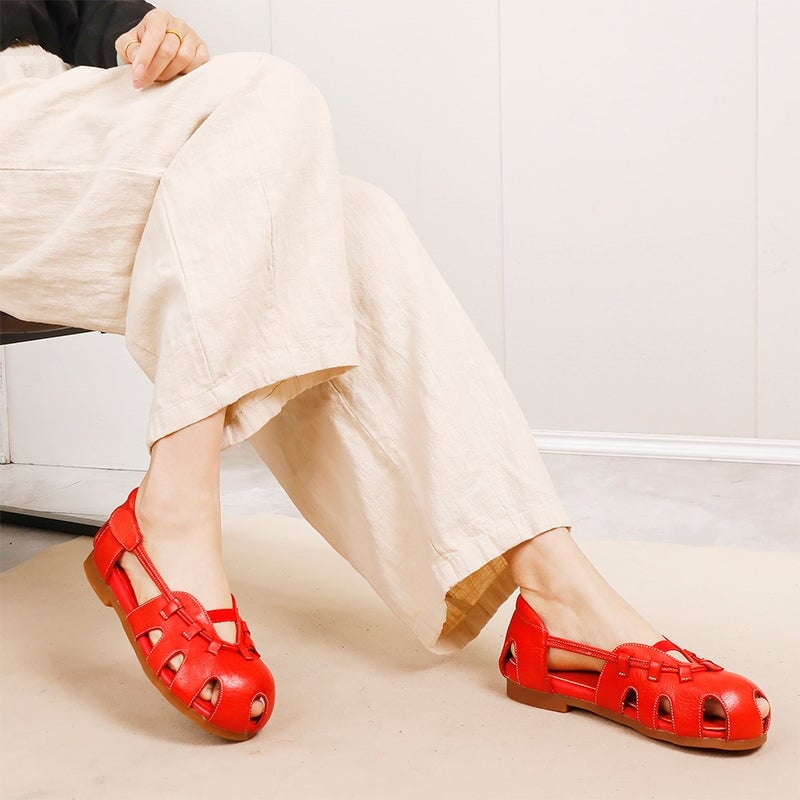 Sandalias de cuero con dise&ntilde;o moderno y transpirable, con punta redonda y aberturas, con cierre de velcro en rojo y negro.