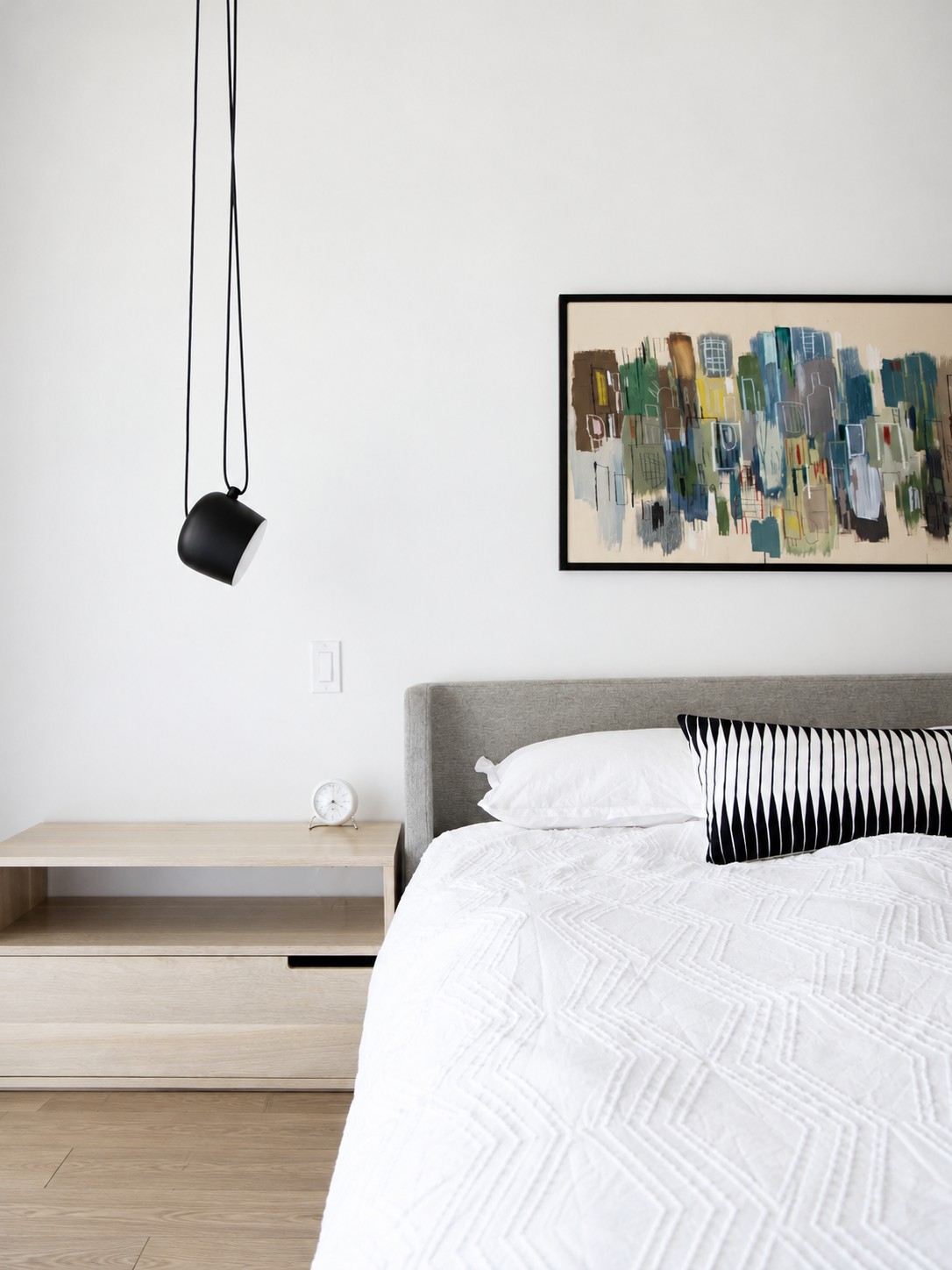 Black adjustable pendant aimed toward bedroom
